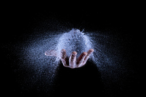 A water balloon exploding in a hand